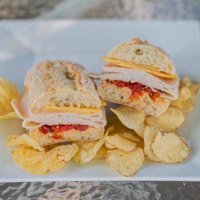 Doc's Special sandwich with turkey, roasted red peppers, cheese and a side of chips.