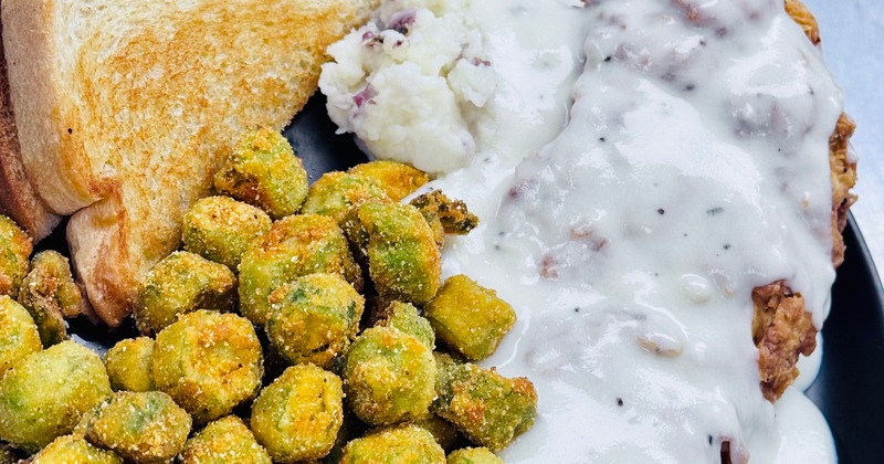 Chicken fried steak served with fried okra and toasted bread