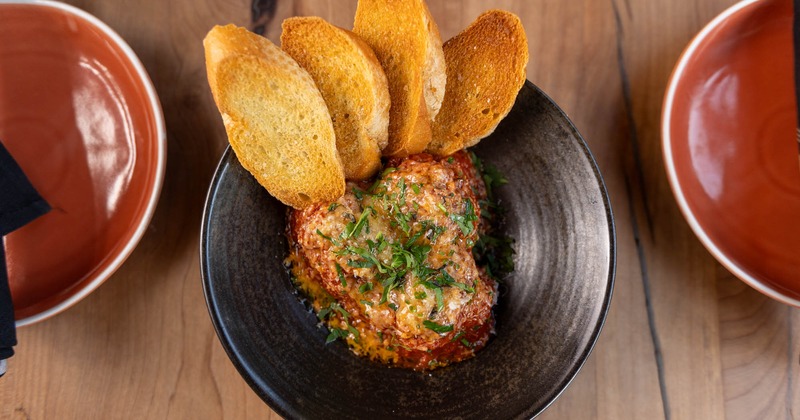 Beef and pork meatballs, with tomato sauce, aged manchego, herbs, and bread