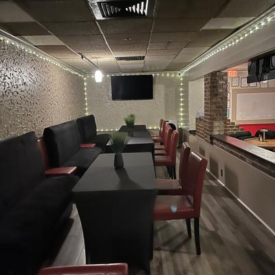 Booth seating along one wall and individual tables with red chairs on the other side.