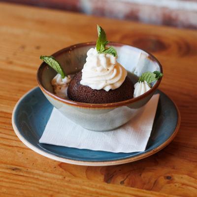Sticky Toffee Pudding garnished with whipped cream and mint leaves.