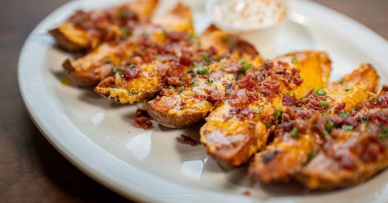 Loaded potato skins topped with melted cheese, crispy bacon, and green chives