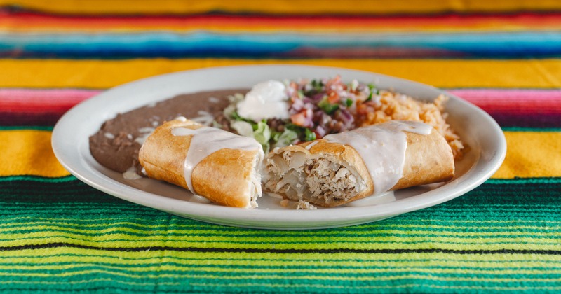 Chimichanga, served with rice, refried beans, sour cream, and salad