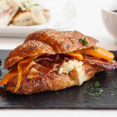 Croissant with cheddar cheese, eggs, and bacon.