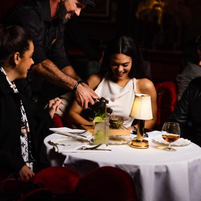 Server attending a table with guests during dinner service.