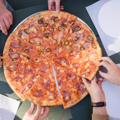 Hands grabbing pizza slices.