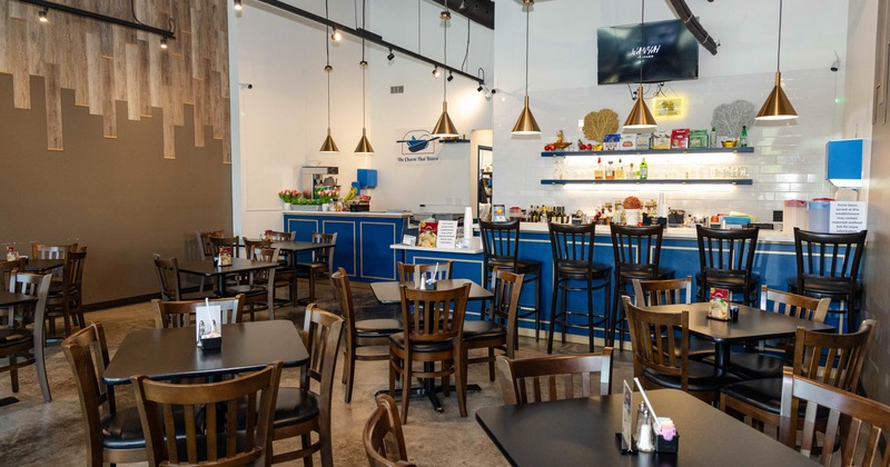 Interior, dining area, wooden top tables for two and four, bar and prep area