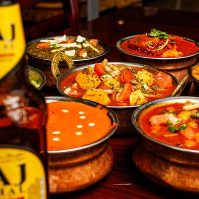 Assorted Indian curries served in traditional copper dishes.