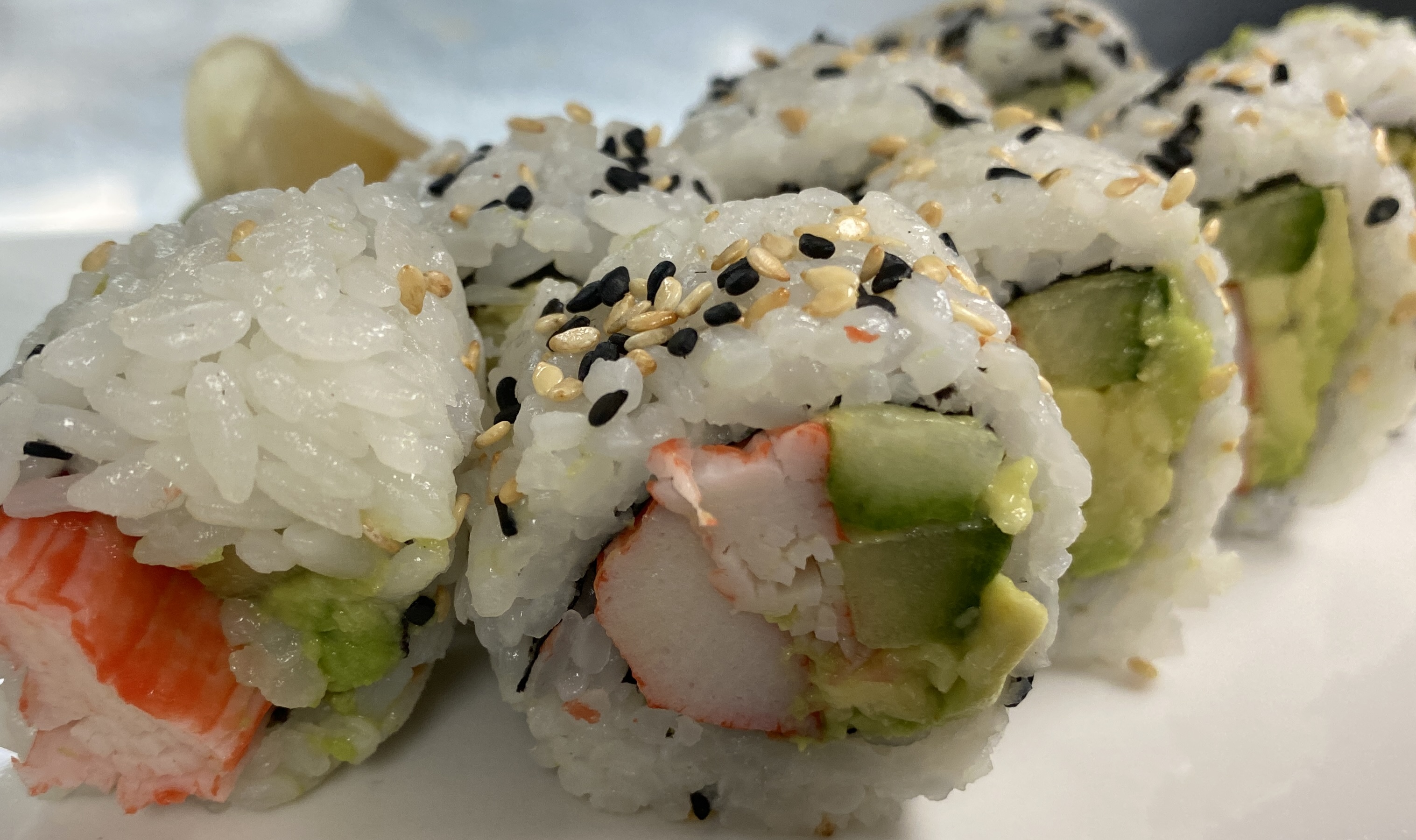 A close up picture of a sushi roll, sliced and displayed on a plate