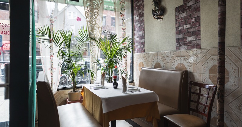 Interior, dining booth with set table in the corner by the window