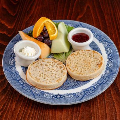 Two crumpets with fruit, jam and cream.
