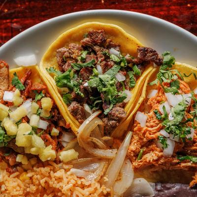 Close up top view of taco plate with Al Pastor, steak and shredded chicken taco