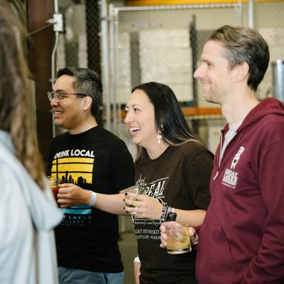 Group smiling and holding drinks inside facility.