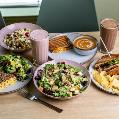 Variety of dishes served on the table alongside two distinct smoothies.