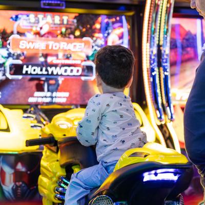 A kid playing an arcade game.