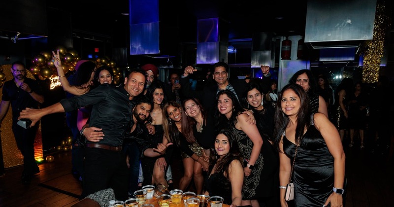 A crowd of party people posing for a shot inside