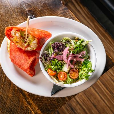 Crispy chicken wrap with a side salad.
