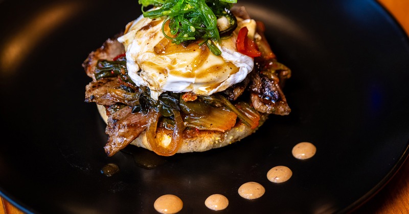 Bulgogi benedict on a dark plate