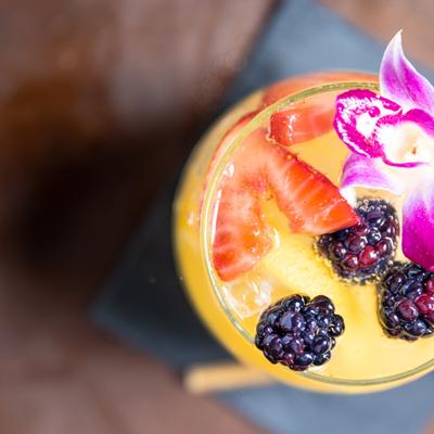 Paraiso cocktail, decorated with purple flower and berries, top view