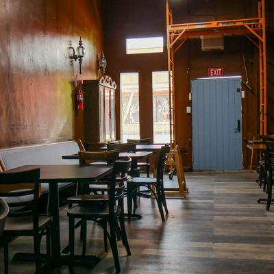 Interior featuring dark wood flooring, wooden walls and table seating.