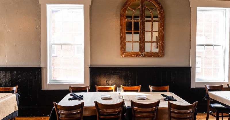 Interior, tables with window behind, set for guests