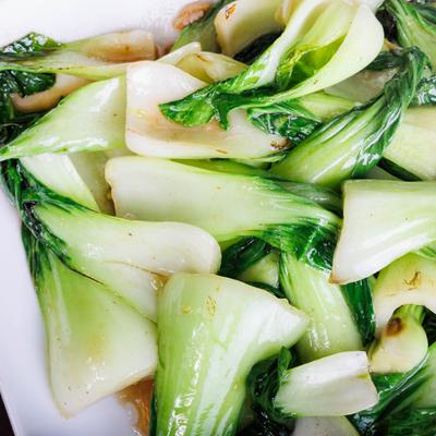 Close-up of stir-fried bok choy with light sauce.