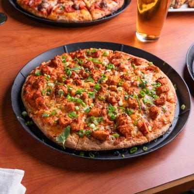 Chicken Tikka Pizza topped with choped green onions.