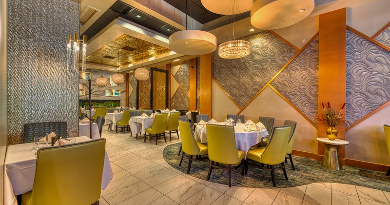 Modern and cozy interior dining area with dining tables set for guests