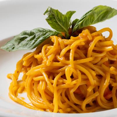 Spaghetti with cherry tomatoes, basil, and olive oil, close-up.