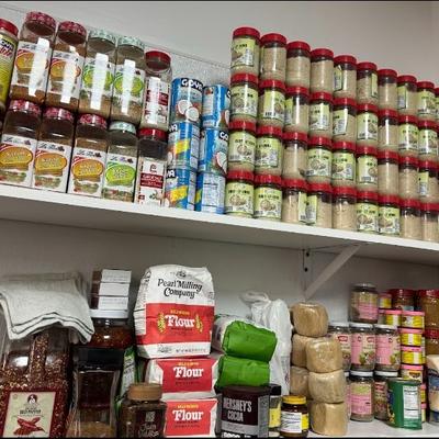 Organized pantry shelves stocked with various spices, flour, and cooking ingredients