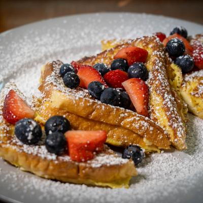 French toast topped with strawberries and blueberries on a plate.