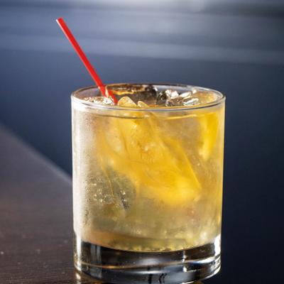 A glass of Old Fashioned sits on the table corner.