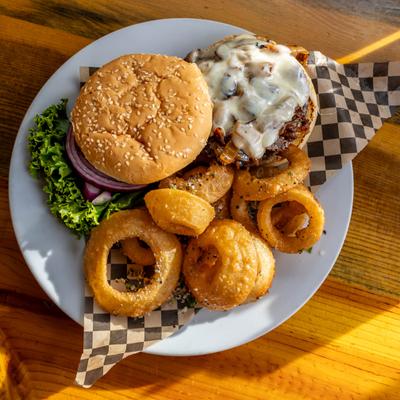 A burger with a side of onion rings, top view.