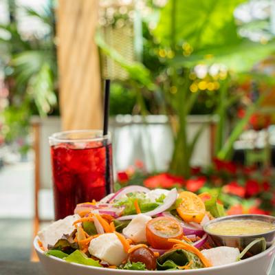 Garden Salad served with a side of dressing and a glass of iced drink.