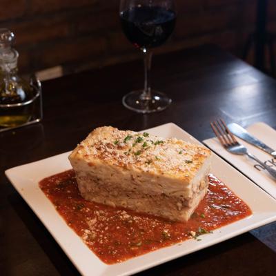 Lasagna with a tomato sauce, served with red wine.