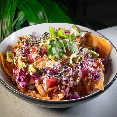 Ahi Tuna Nachos, with fried wontons, tomatoes, cheese, cabbage, sweet soy, and cabin dressing.