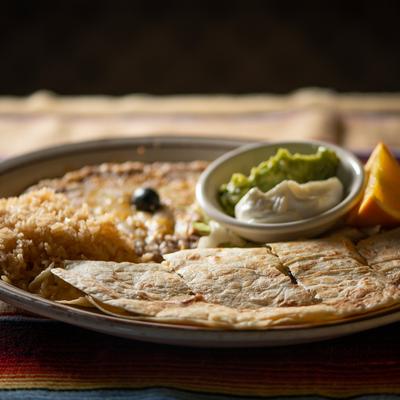 Quesadillas, with sour cream, guacamole, rice, and beans.
