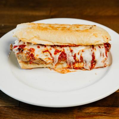 Pizza burger with marinara sauce and melted cheese on a hero bun.