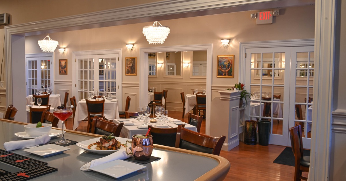 Interior of elegant and cozy dining area with dining tables set for guests