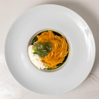 Spaghetti with tomato sauce, crispy basil, and burrata cheese.