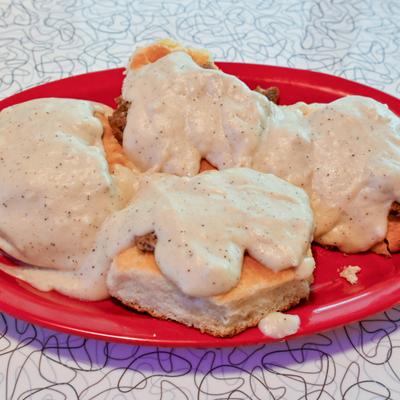Biscuits and Gravy served on a red plate.
