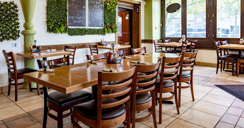 Interior dining area with wooden dining tables ready for guests