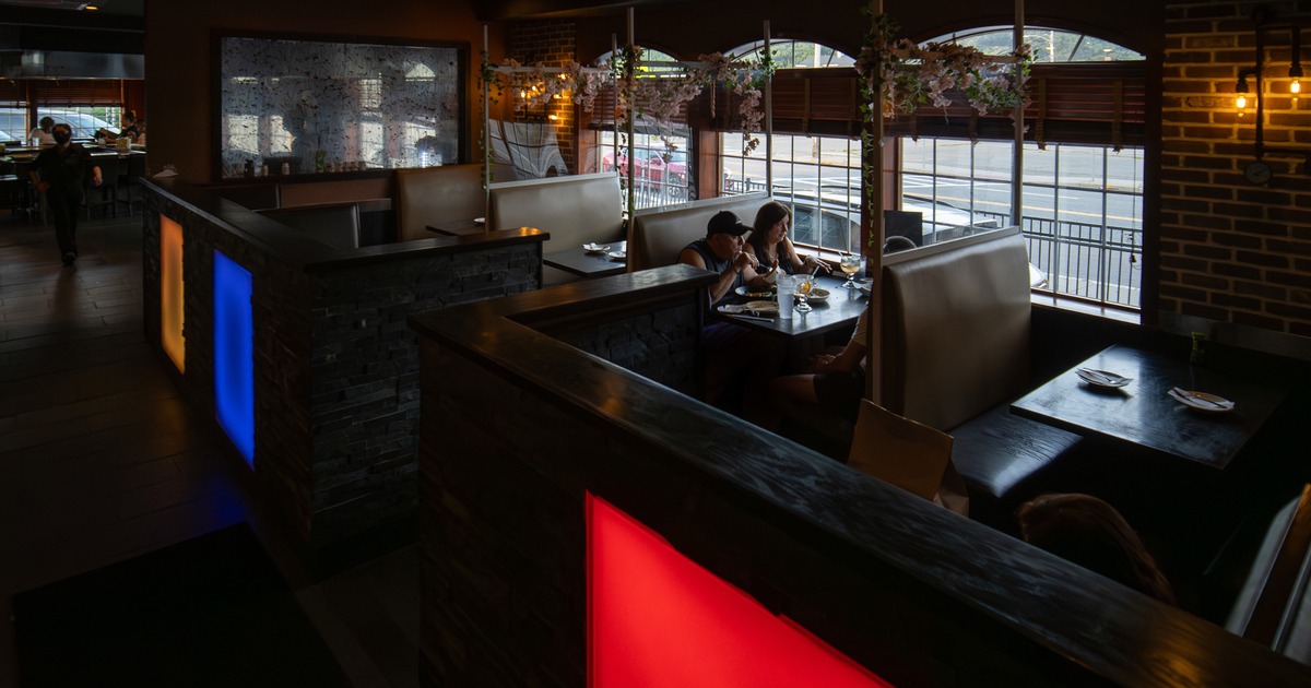 Interior dining area with upholstered dining booths lined up along windows