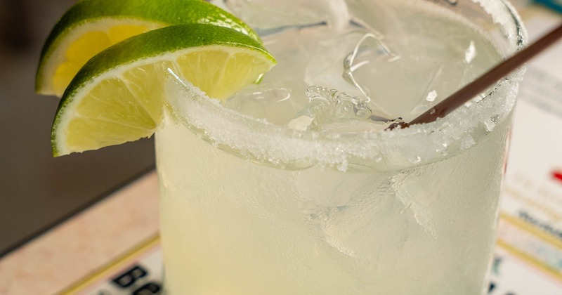 Margarita cocktail garnished with a salt rim and lime slices