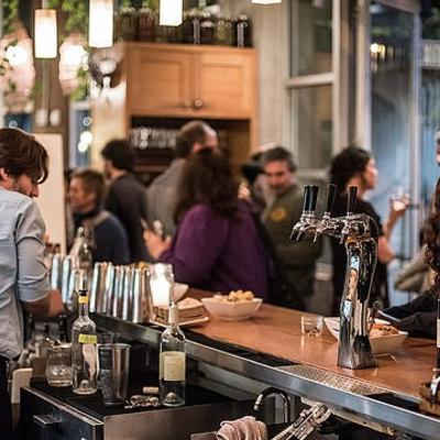 Bartender preparing drink while event guests socialize at Gather restaurant in downtown Berkeley.