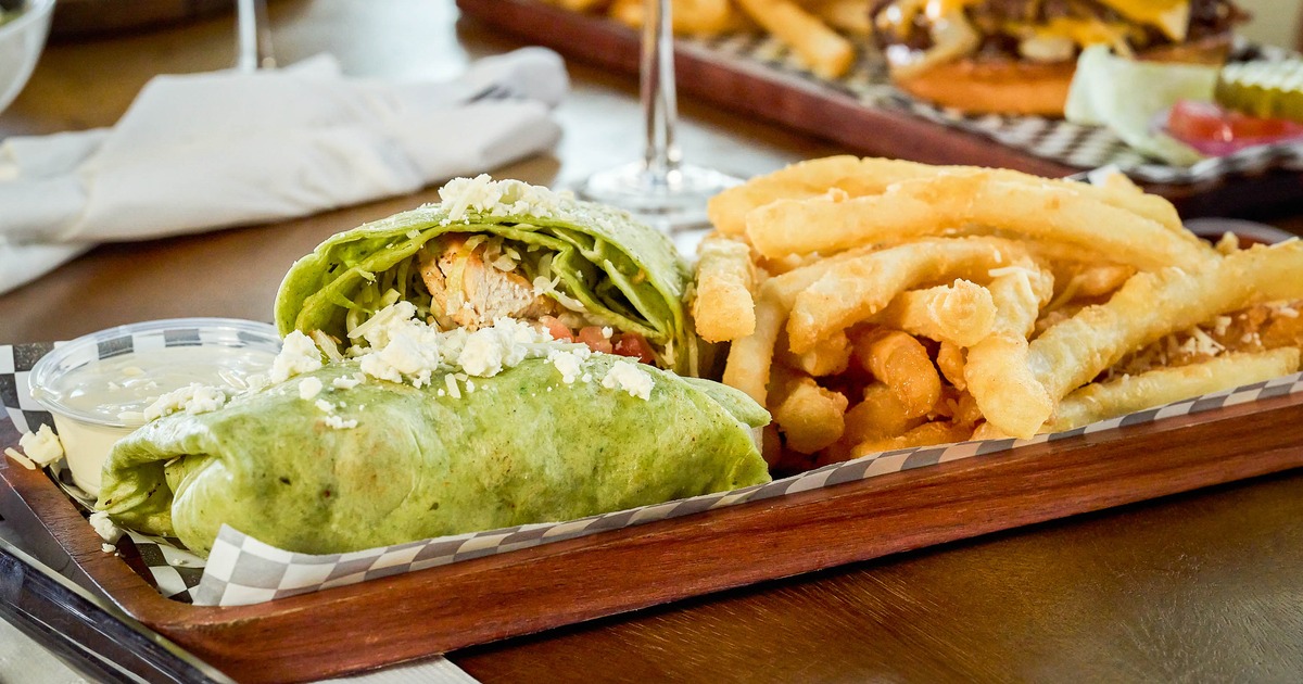 Mediterranean Wrap served with french fries on a wooden board