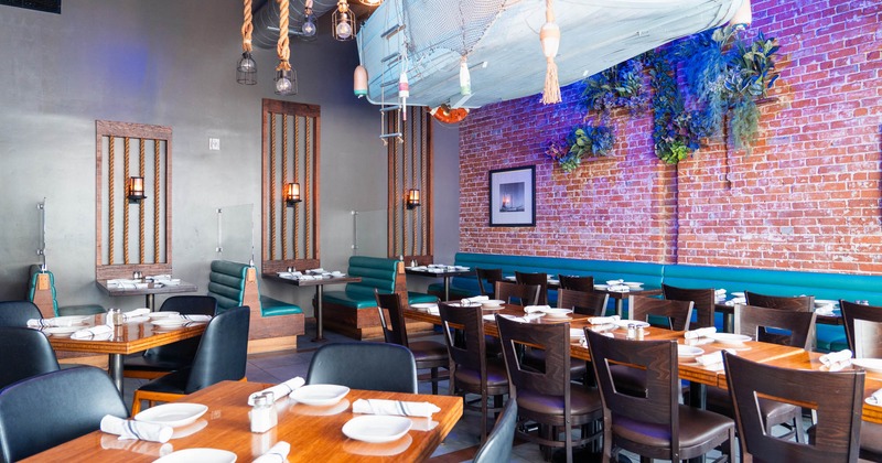 Interior, dining area, seating booths with tables, regular tables for four, red brick wall