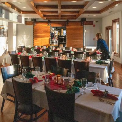 A cozy, warmly lit restaurant with tables set for a festive event.