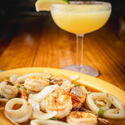 Seafood plate with Cancun Sauce, accompanied with a glass of Margarita.