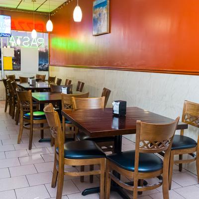 Dining room with wooden tables and orange wall.